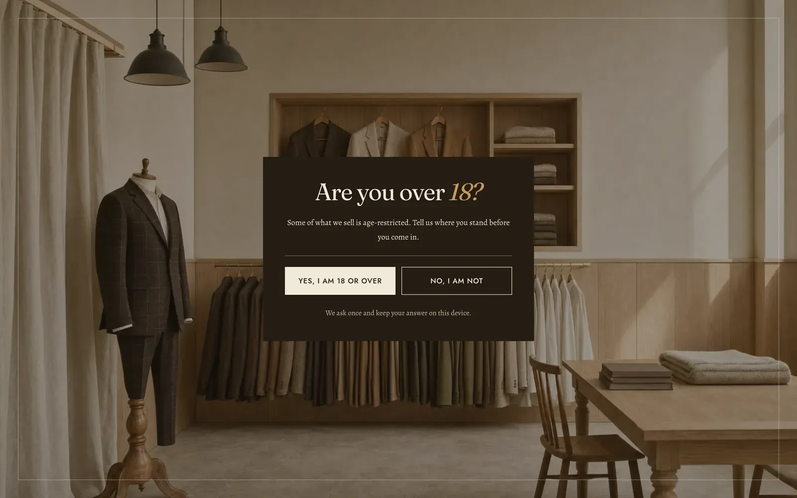 The Lapels age verification gate filling the screen: a photograph of a fitting room hung with suits and folded cloth, with a dark panel over it asking Are you over 18, two buttons reading Yes, I am 18 or over and No, I am not, and a line underneath saying the answer is kept on this device.