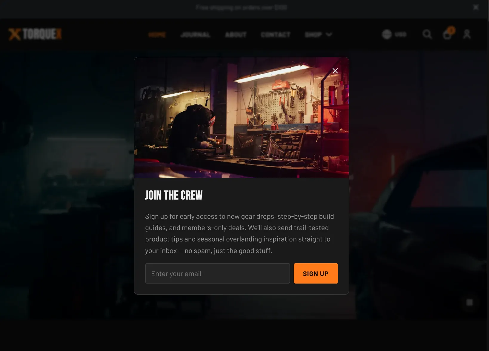 The Torquex newsletter popup centered over a dimmed page: a dark two-panel modal with an editorial photo of a light-bar-lit off-road truck on the left, and on the right a "Join the crew" heading, supporting text, an email input, and an orange "Sign up" button with a close X in the corner.