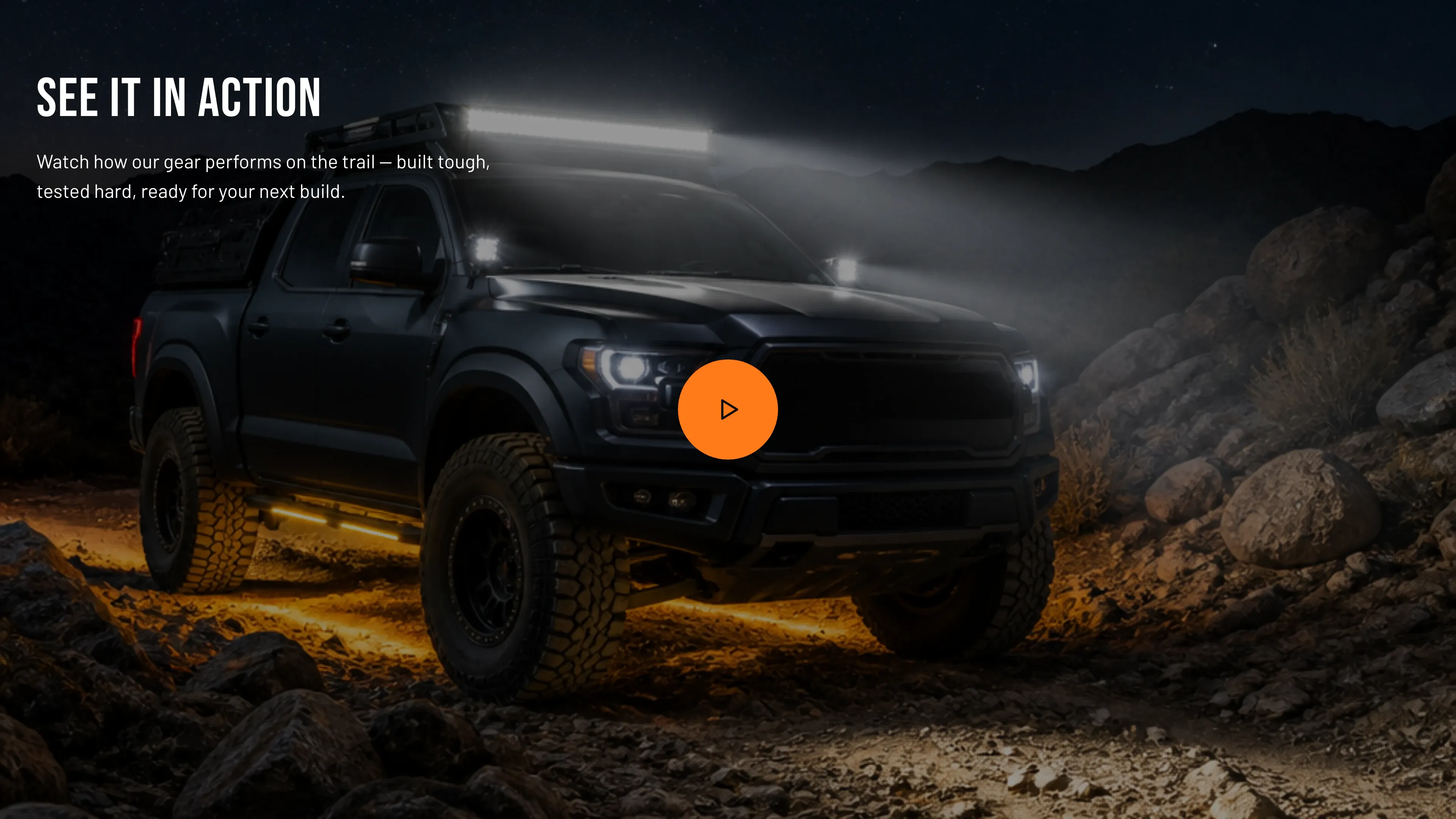 The Torquex video section — a night-time cover photo of an off-road truck with a glowing roof-mounted LED light bar on a rocky trail, a round orange play button centered over it, and the uppercase heading "See it in action" with supporting copy overlaid top-left in light text